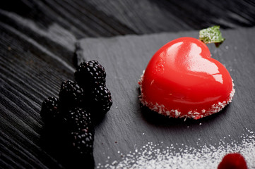 Massovoe cake red heart-shaped dessert on a date. Sprinkled with cocoa and powder.