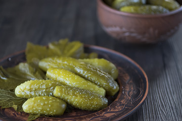 Pickled cucumbers on brown plate.