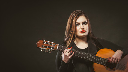 Handicapped girl holding guitar.