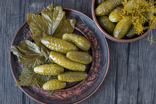Pickled cucumbers on brown plate.