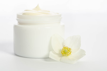 Fototapeta na wymiar Cute flower and a jar of natural body cream isolated on white background