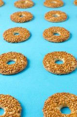 Round cookies with sesame seeds on a bright blue background.