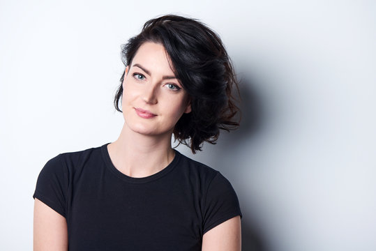 Closeup Of Bright Brunette Woman In Black Tshirt, Standing Near The Wall With Shadow