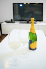 Bottle and glass of champagne in a living room