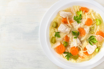 Chicken soup with noodles, overhead photo with copyspace