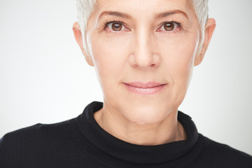 Portrait of beautiful senior woman in front of white background.