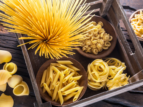 Different pasta types on the wooden table. Top view.