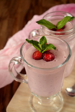Protein cocktail with strawberries and mint in an Irish mug on wooden background