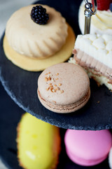 Cakes on a dark slate bunk stand. Desserts. Sweet table