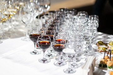 out catering, glasses with white and red wine, champagne, whiskey, juice or mineral water are on  table for the guests of  event
