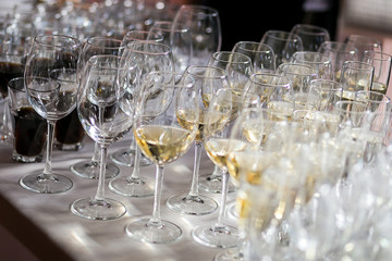 out catering, glasses with white and red wine, champagne, whiskey, juice or mineral water are on  table for the guests of  event