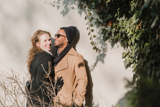 Smiling couple standing against wall