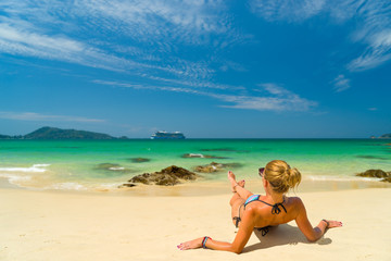 Fototapeta na wymiar Young woman in bikini laying by the tropical sea