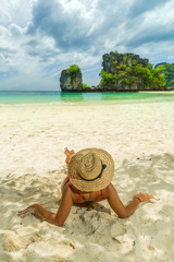 Young woman in bikini laying by the tropical sea