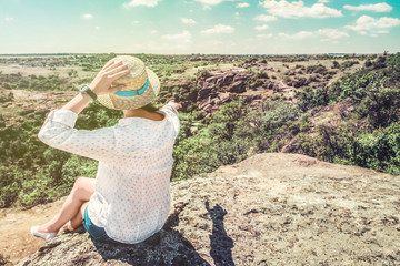 girl on a rock pointing into the horizon