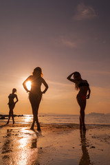 Silhouette of three girls on the beach at sunset