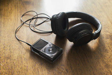 Mp3 music player with headphone on wooden table