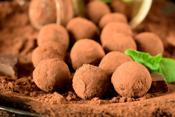 Chocolate truffles covered with cacao powder on a black plate