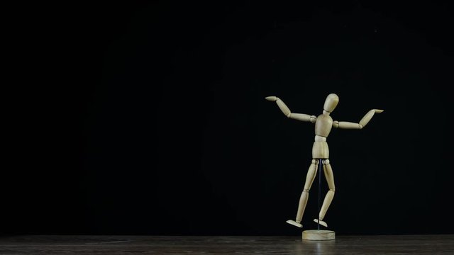 Stopmotion wooden figure dummy in studio on black background rotating and showing i dont know