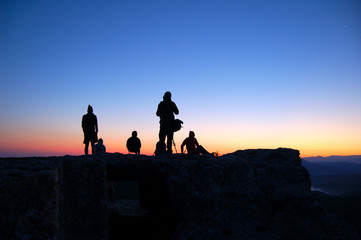 Tourists watch the sun rise on the mountain
