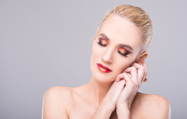 Model posing with eyes closed wearing professional make-up.