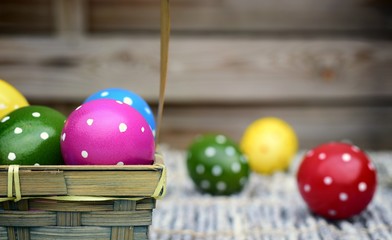Holiday,event and Easter concept-hand-painted Easter eggs in a basket on a wooden background.