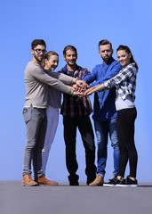 group of young people clasped their hands together