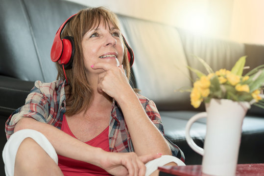 Happy mature woman listening to music, light effect