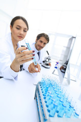 Woman looking at test tubes with colorful liquids