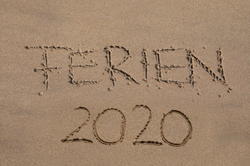 Das Wort FERIEN 2020 in den Sand geschrieben