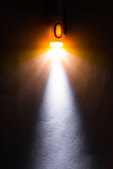 Fototapeta na wymiar Orange light beam of flashlight pen on dark background.
