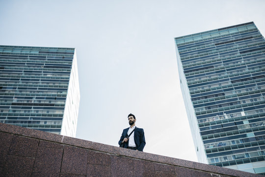 Businessman standing in front of office towers