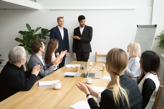 African american boss or black hr executive ceo introducing new hire employee to corporate team applauding at group meeting, office workers clapping hands welcoming coworker with friendly ovation