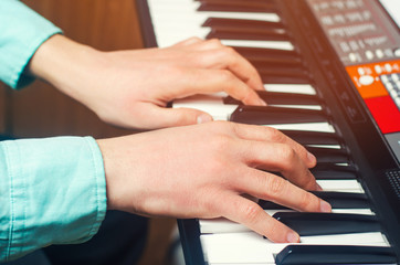 Fototapeta premium Close-up of a music performer's hand playing the piano, man's hand, classical music, keyboard, synthesizer, pianist