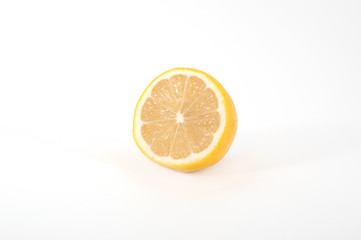 A slice of a juicy ripe lemon-shaped view at an angle isolated on a white background.
