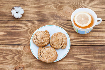 Obraz na płótnie Canvas Plate with homemade cookies with sesame and aromatic tea with lemon.