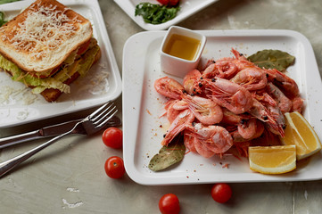Beer snack in the pub or bar. Shrimp, mouth-watering sandwich and Golden onion rings.