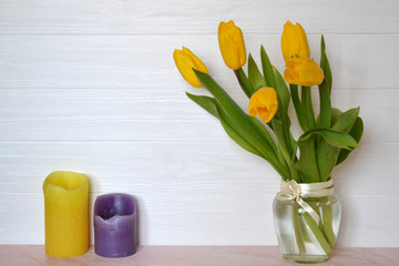 Yellow tulips in vase on the table. Spring background.