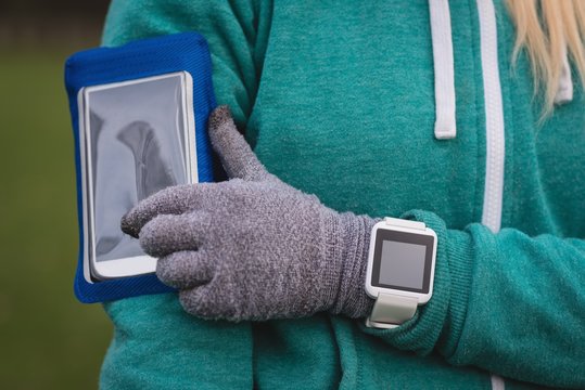 Woman Using Mobile Phone With Arm Band In The Park