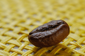 Set of fresh roasted macro coffee beans, yellow wicker basket background.