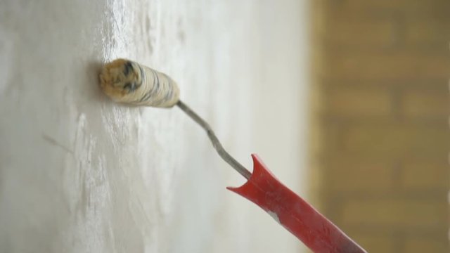 A man painting a wall. Repair in the apartment