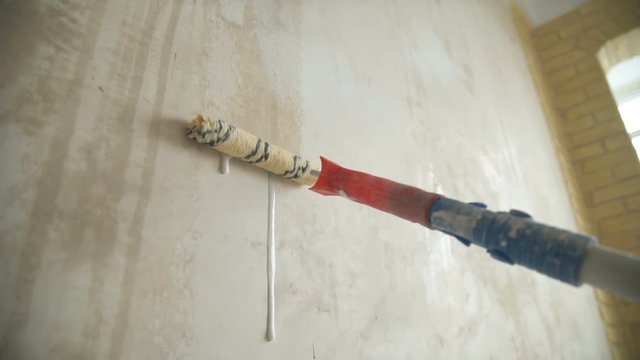 A man painting a wall. Repair in the apartment