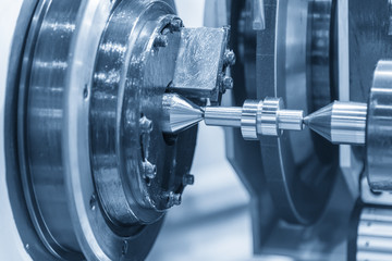 The cylindrical grinding machine with the steel cam shaft.Automotive part manufacturing process.