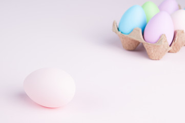 pastel colored easter eggs on a pale pink background