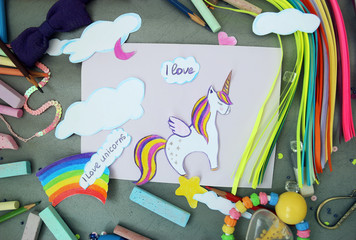 applique with a picture of a unicorn and a rainbow with children's chalk and pencils on a applique...
