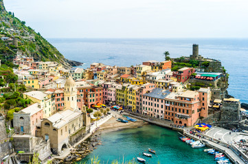 Fototapeta na wymiar The small fishermen village of Vernazza, with its colorful houses and its church around its little port, is one of the five towns of the Cinque Terre in Liguria, Italy.
