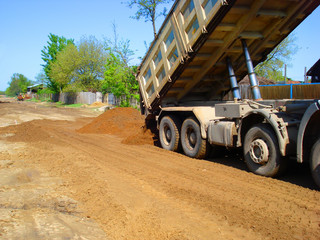 View of dump truck dumping earth