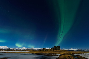 Fototapeta na wymiar The Northern Light at the mountain in Iceland. Landscape with green bands of Aurora Borealis. Nightscape magical.