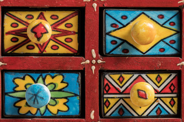 Front side of a small painted box with drawers for spices