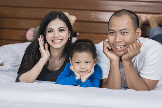 happy asian family in the bed